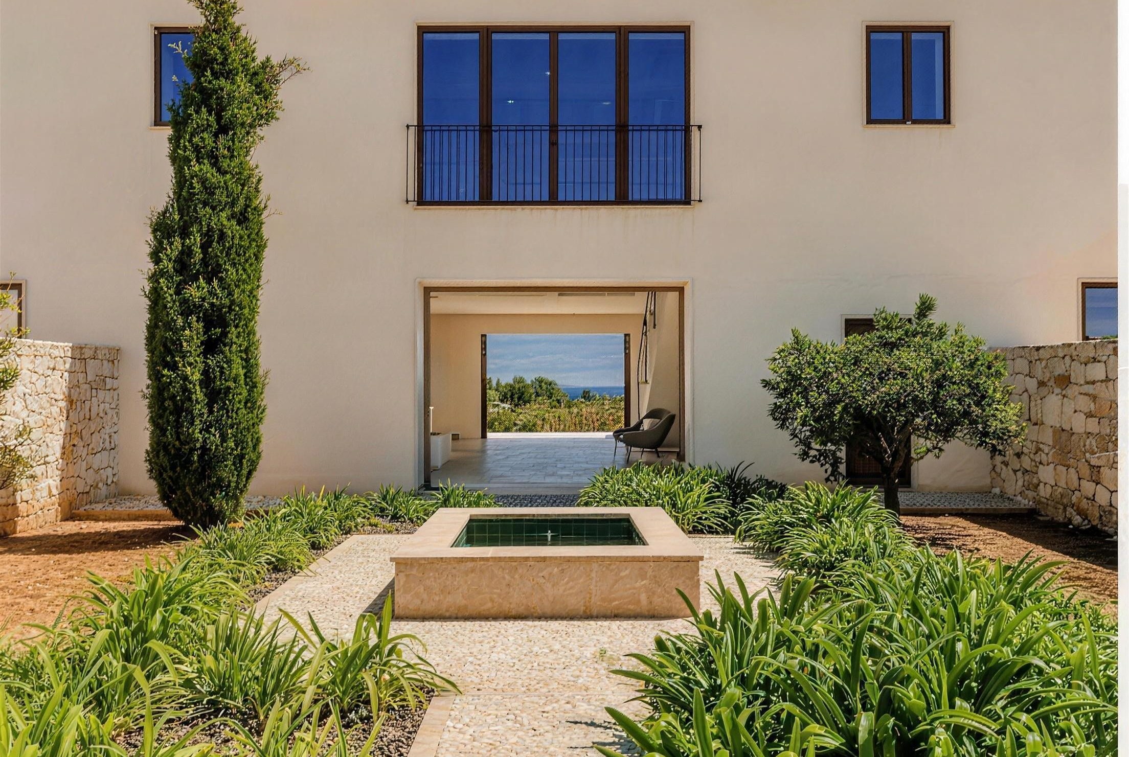 Lucera, Cala Llombards, Mallorca – entrance framed by natural stone walls and a fountain